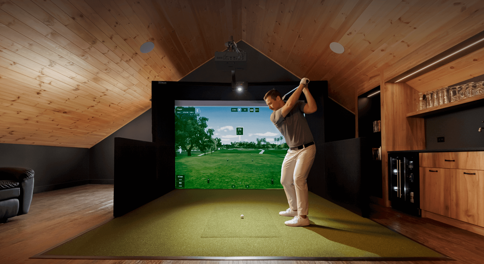 Simbooth simulator in Attic of house with righty golfer about to hit a ball